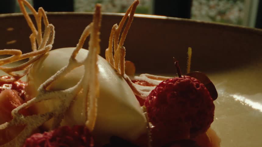 Close up of a dessert with flowers on a rounded plate