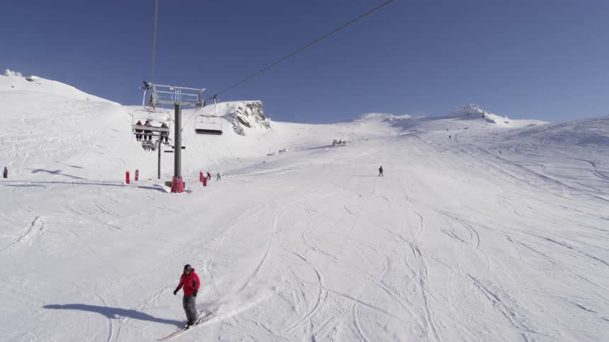 Skiers skiing down a run at a mountain ski resort