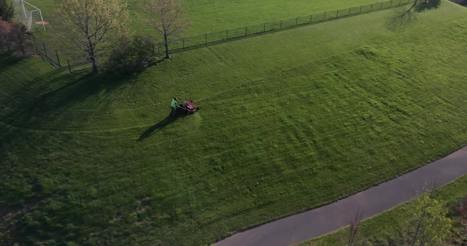 Overhead view of a person on a machine cutting grass