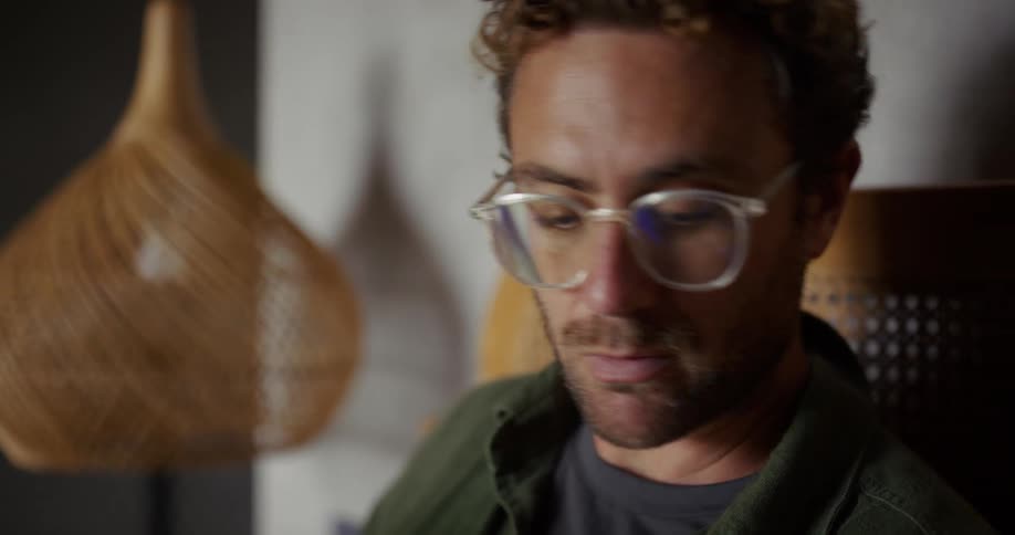 Man with glasses and beard sitting looking to the sides