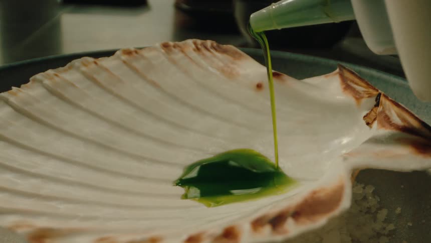 Green sauce being poured into a ladle