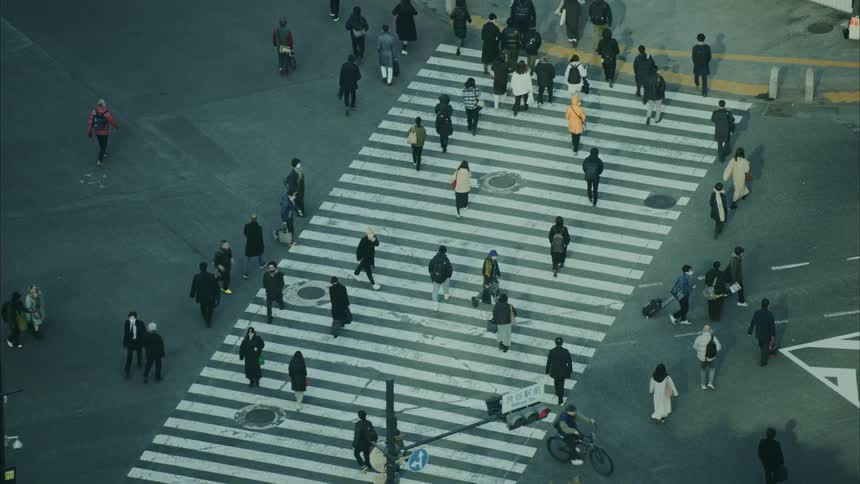 Pedestrians walking across busy intersection in a metropolitan area