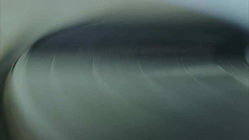 A closeup view of a vinyl record spinning on a turntable