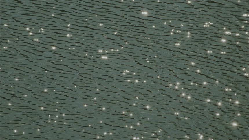 Sun glistening off lake as it flows with the current