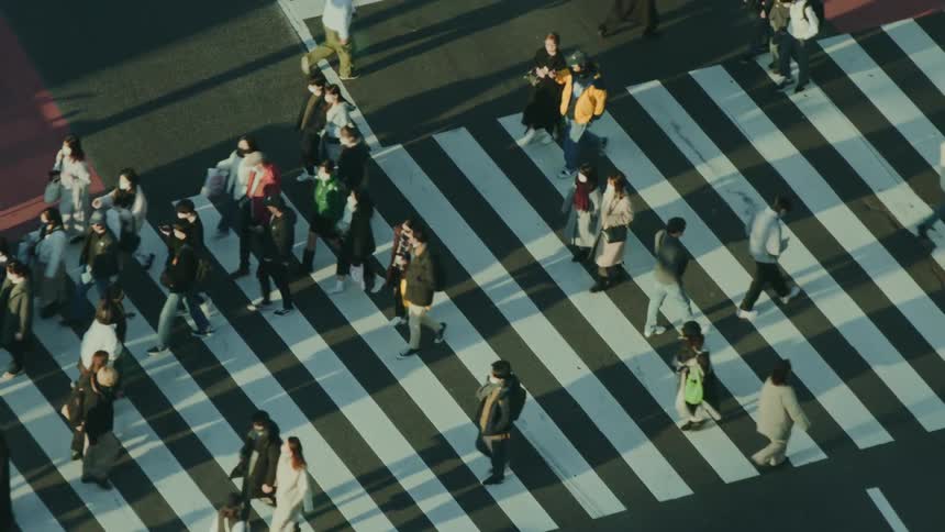 Several people crossing an intersection in the city