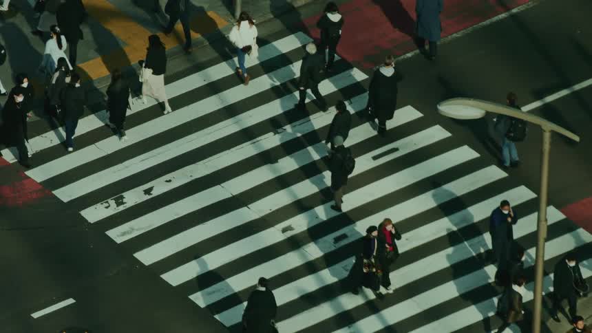 Pedestrians cross the street through the city