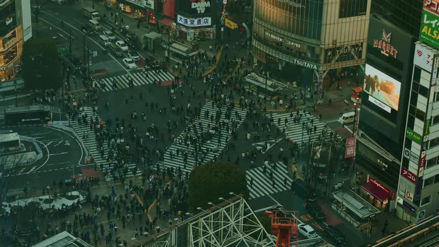 Crossroads in a metropolis with vehicle traffic and people crossing the street