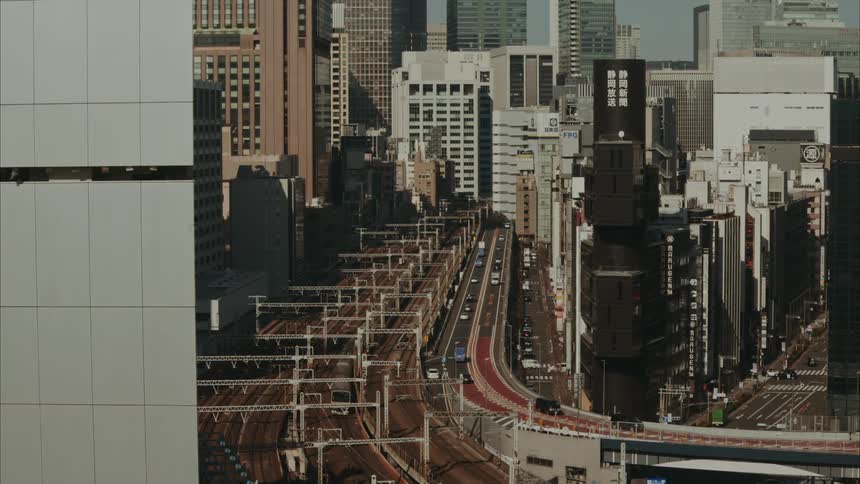 Highway next to train tracks in a metropolis with skyscrapers
