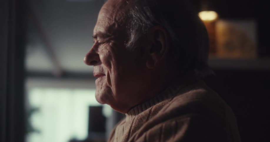 Side portrait of a senior man in a happy indoor space