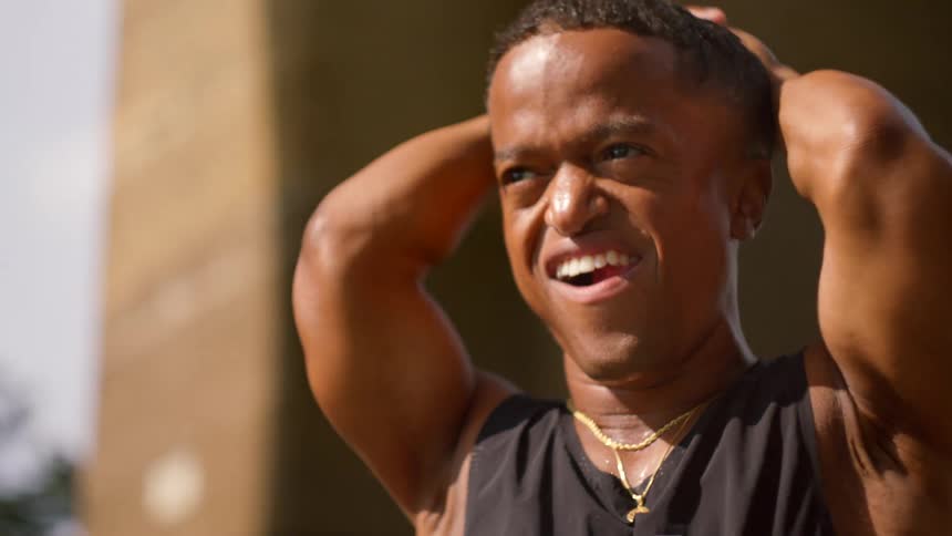 Man with happy facial expression and arms behind head