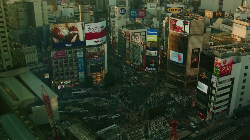 Tokyo metropolises at an intersection with vehicle and pedestrian traffic