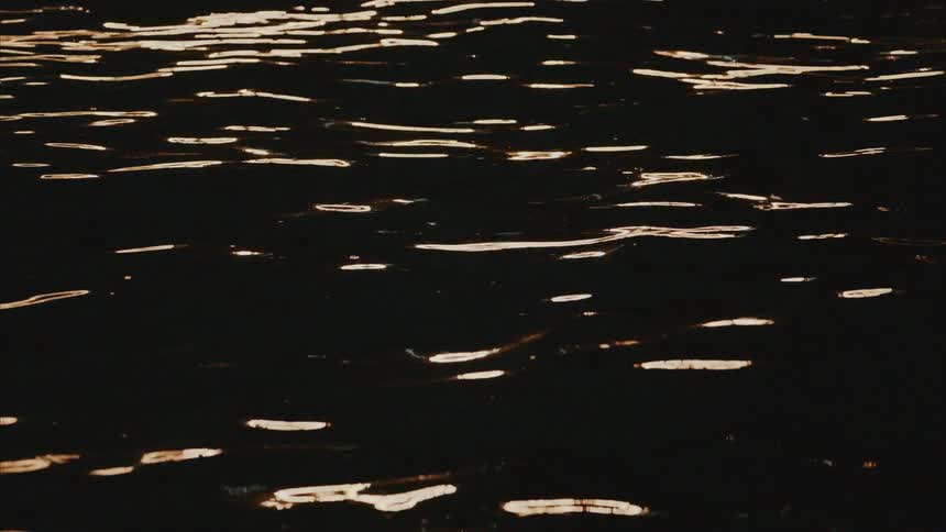 Sea water with small calm waves and the reflection of the sun