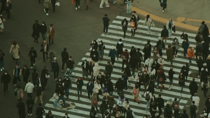 Pedestrians walking across busy crosswalk intersection in a metropolitan area