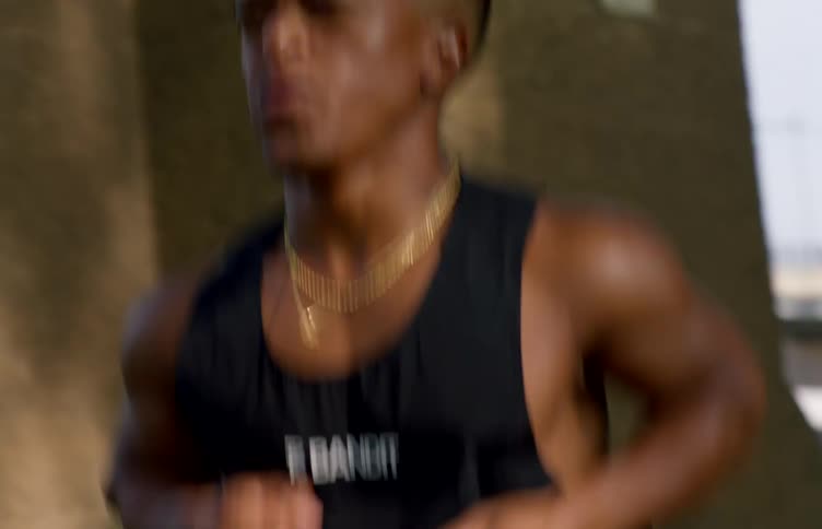 Man in tank top running with determined expression