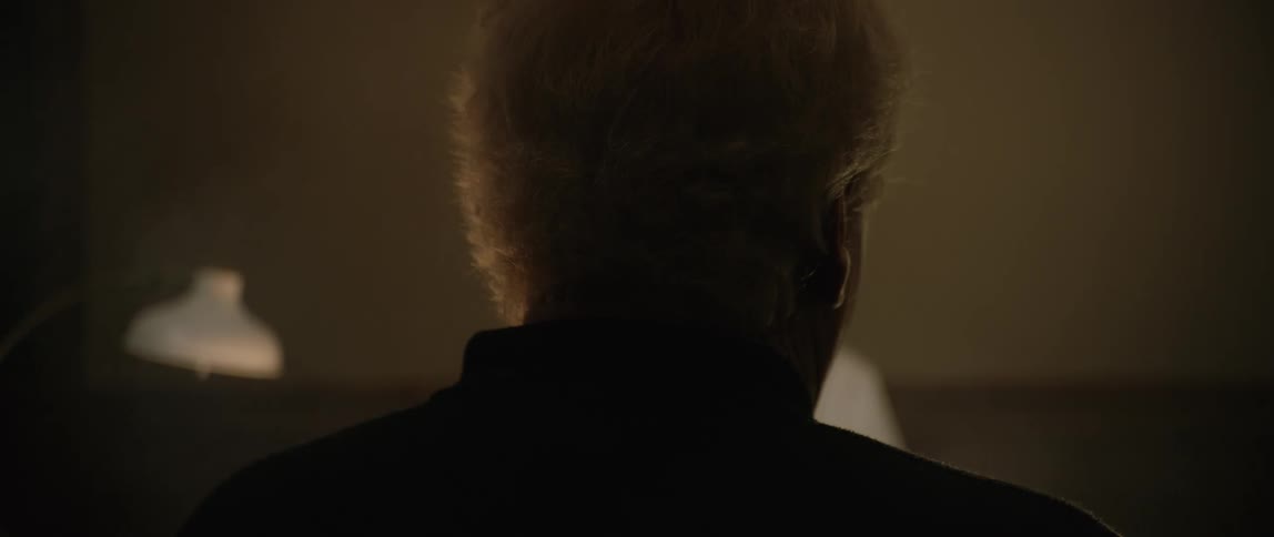 Silhouette of a person from behind in a lowlight indoor environment