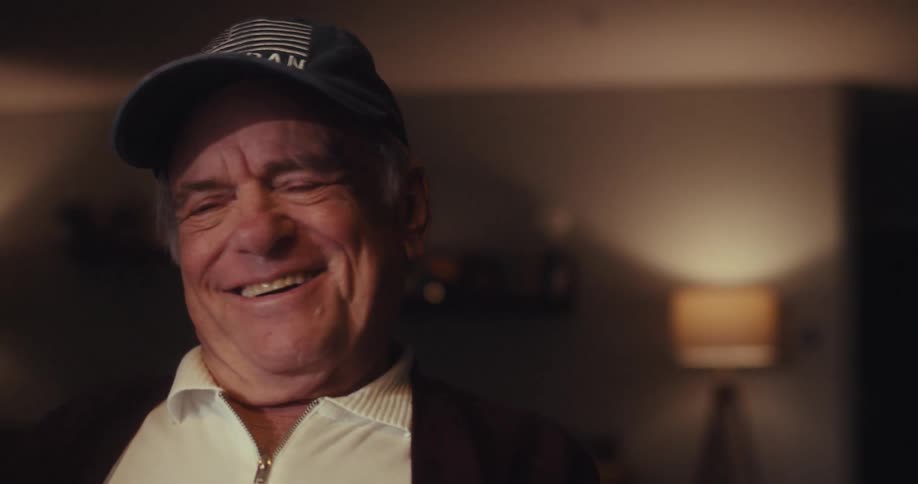 Elderly man watching someone on his laptop and laughing