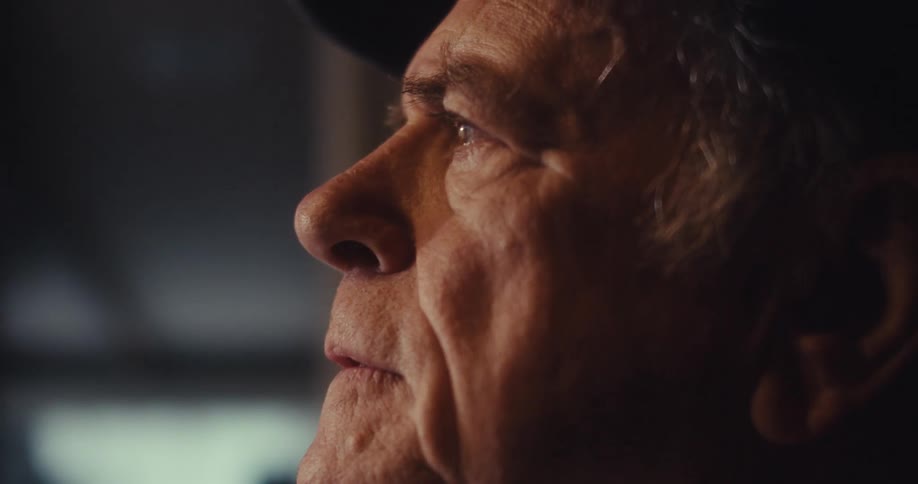 Old man in cap with neutral expression getting happy