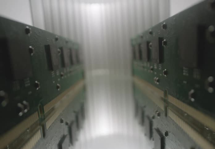 A close up shallow depth of field shot of parallel rows of circuit boards or ram modules in a metallic industrial environment