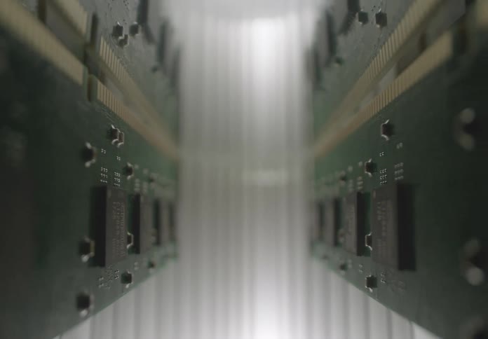 Green circuit boards with gold chips and tracks are aligned parallel in centered focus