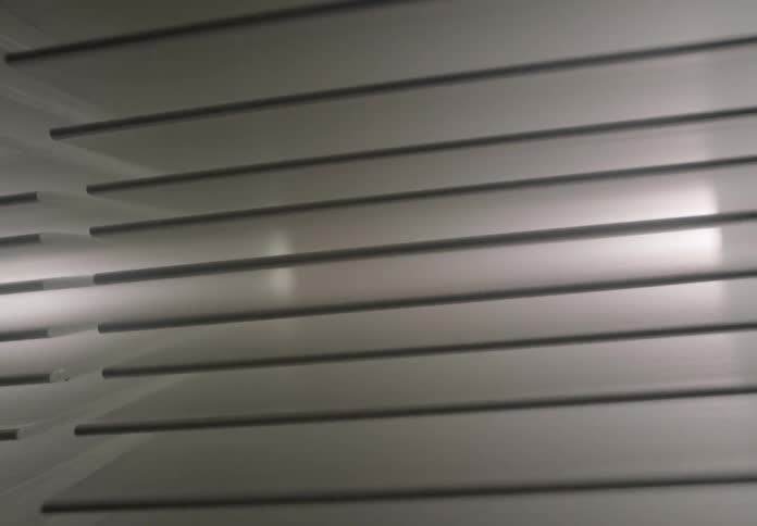 A rotating dutch angle shot reveals a modern geometric ceiling with reflective lighting creating a sleek abstract look