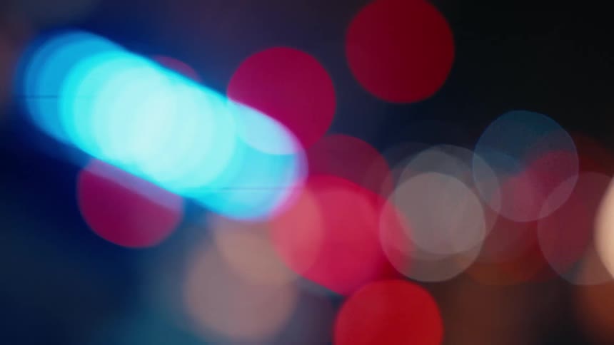 Cluster of blurry circles of light in various colors rotates against a dark background