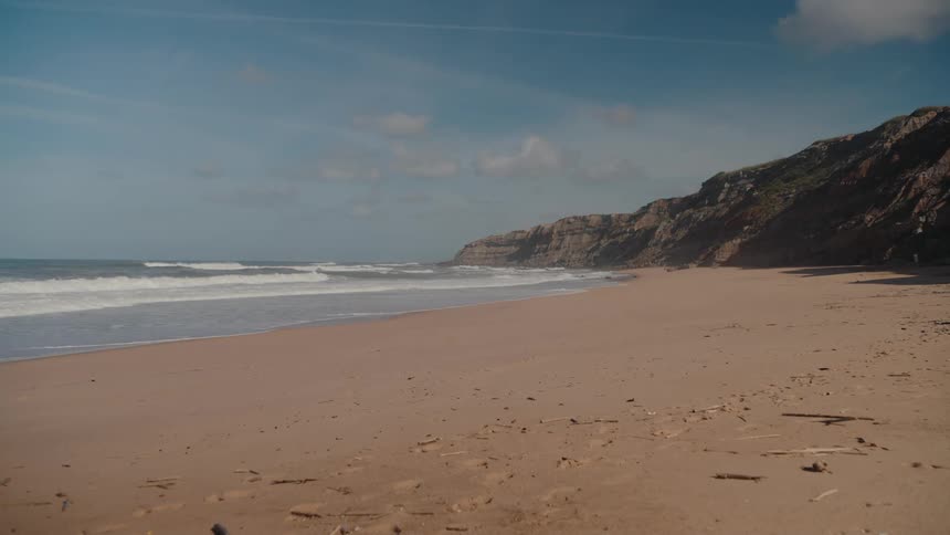 The waves move slowly over the sand on the beach