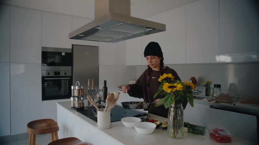A woman is serving food from a pan