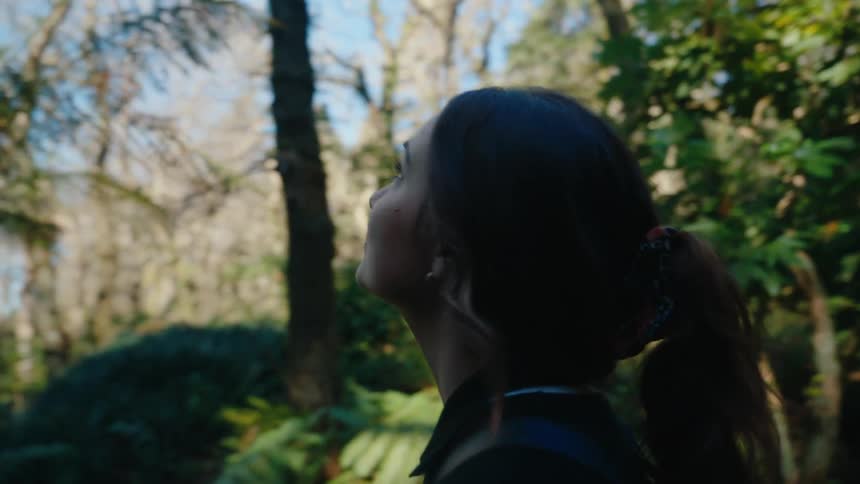 A woman is standing in the middle of the forest