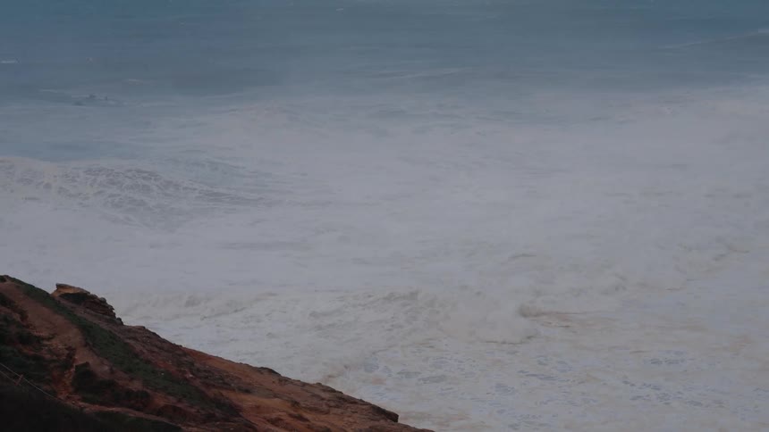 The waves surround the shore line and crash on the rocks