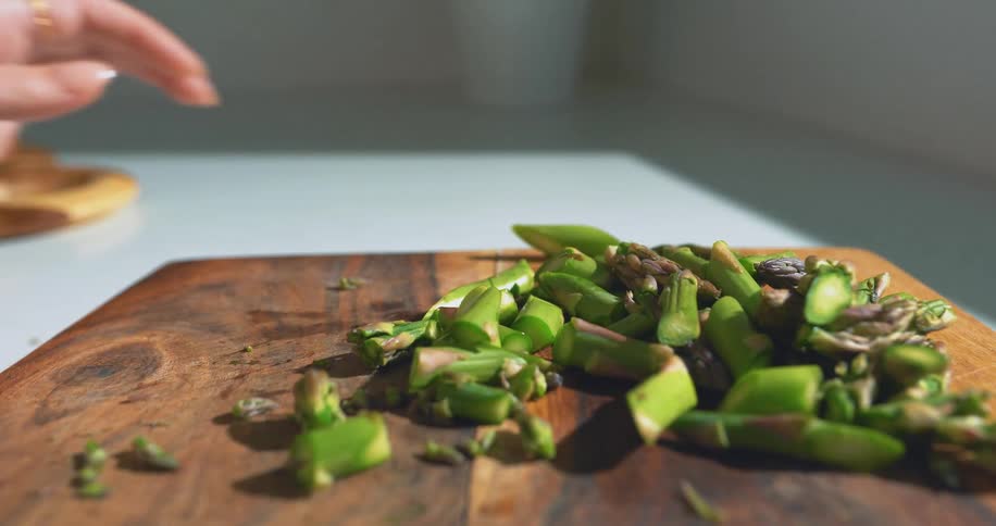 Pair of hands with a knife cutting vegetables on a wooden board