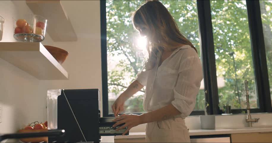A woman is mixing pasta in a pot