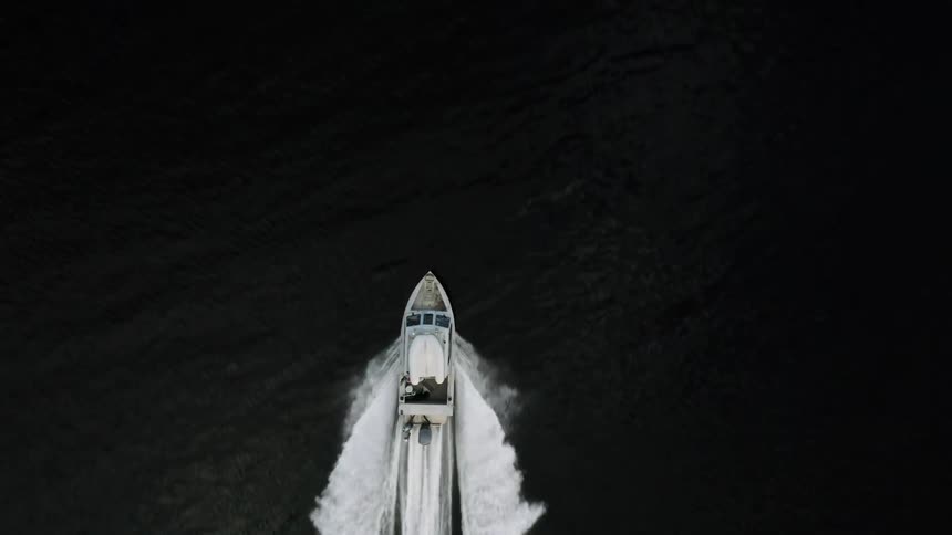 Motorboat leaves a wake while traveling across the water during the daytime