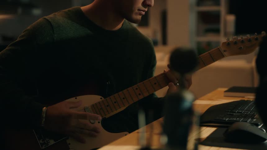 Man sitting in a room playing guitar