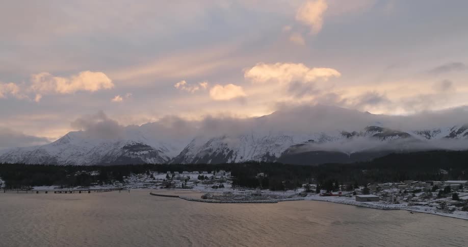 A snow covered mountain range is by the coastal town