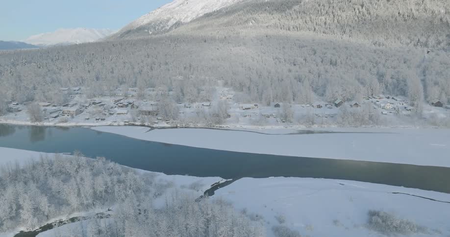 A rural town and surrounding nature is covered in snow