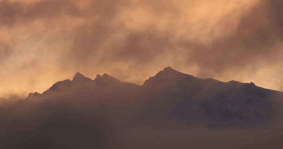 Silhouette of mountains against a reddish sky