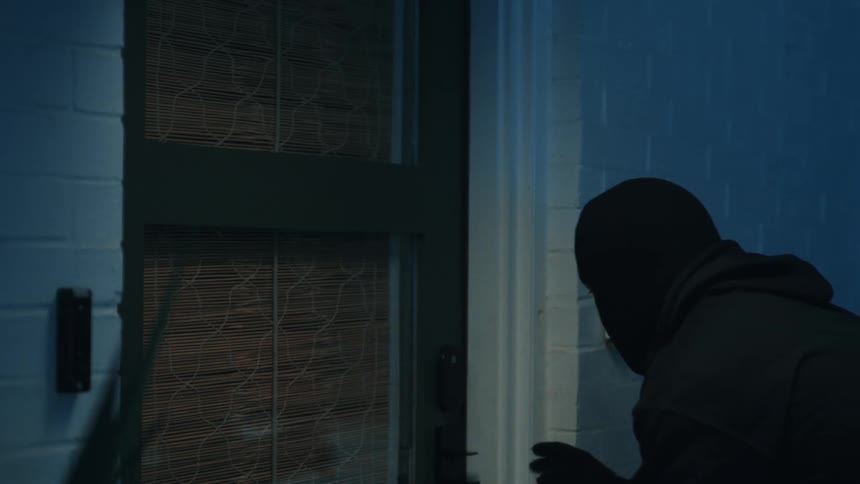 The burglar is picking the lock on the home