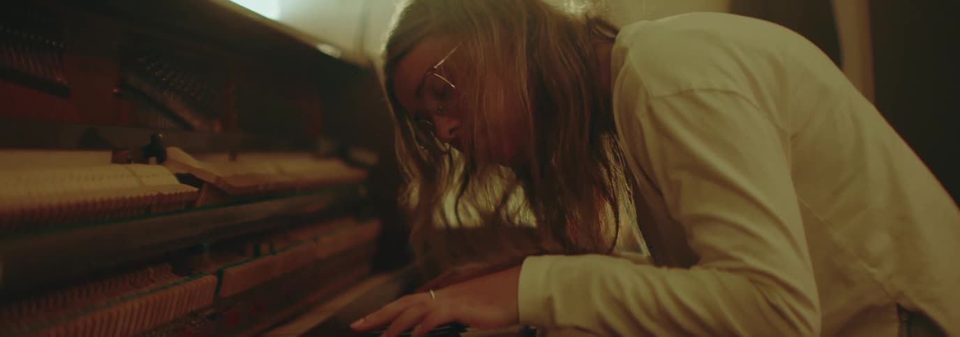 Woman sitting indoors playing piano