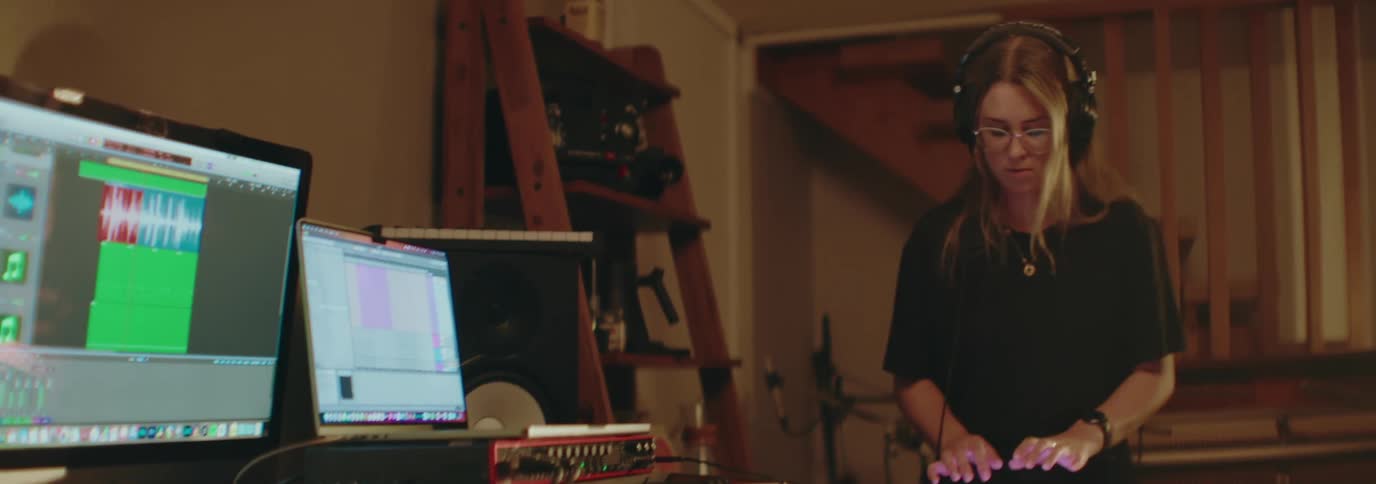A woman is using a soundboard and producing music