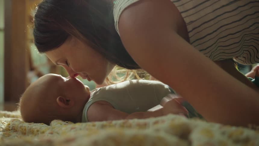 A mother kisses her son on the cheek
