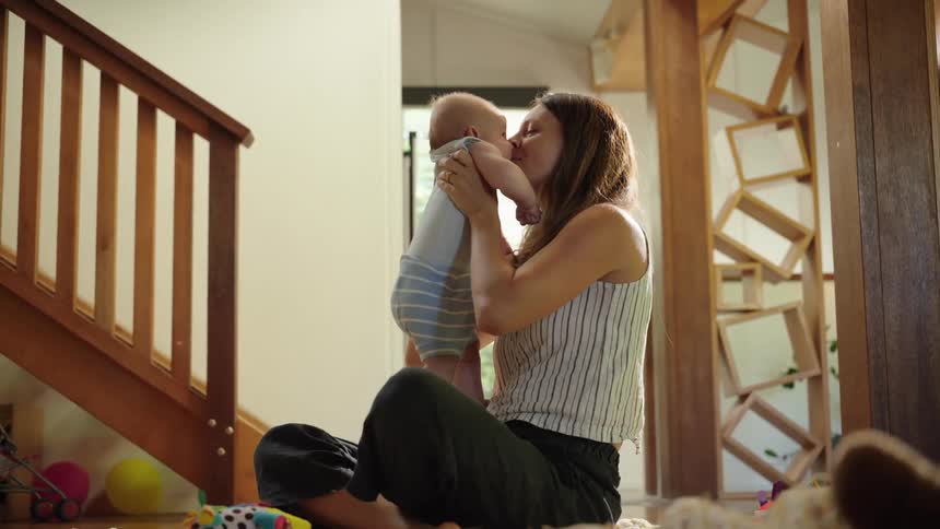 Mother sitting playing with her baby son
