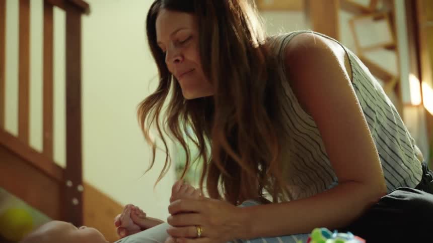 Mother playing with her baby lying down
