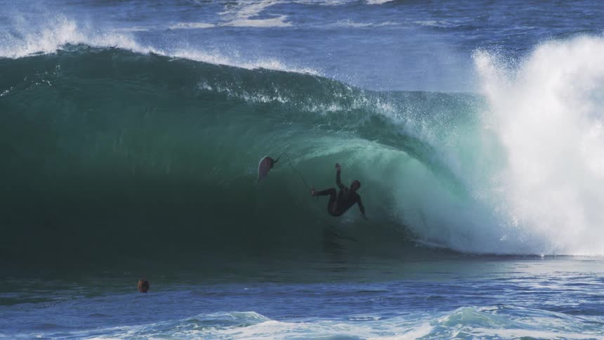 Slow motion of surfer falling off his surfboard inside a large barrel wave