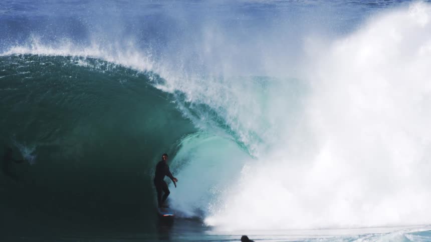 Surfer surfs a huge wave in the ocean