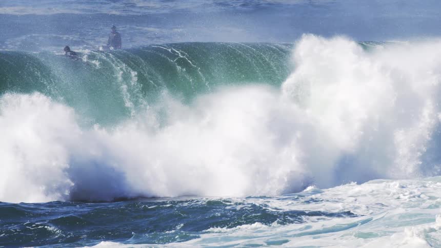 A powerful ocean wave crashing with immense force against the shore creating a dynamic and turbulent display of water