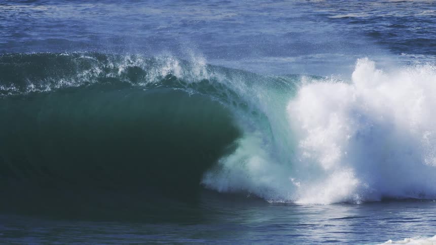 Turquoise blue tubular wave breaking in the ocean