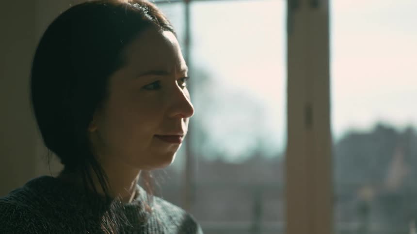 Woman stops to think while stirring a pot of food in the kitchen