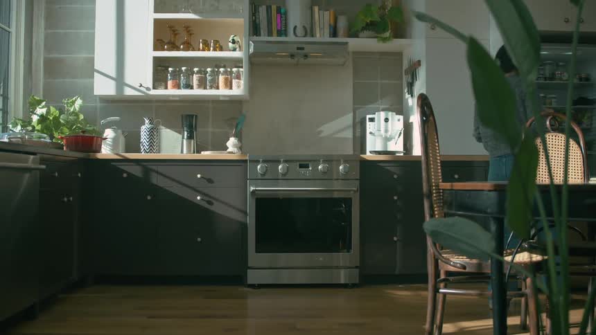 Woman picks packed food from the refrigerator and places it on the kitchen counter top