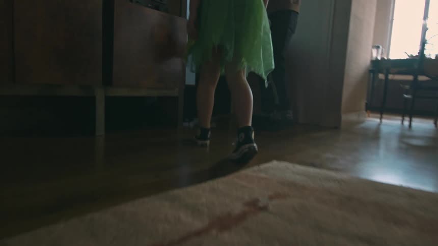 Girl tying her sneakers and leaving the house with an adult person