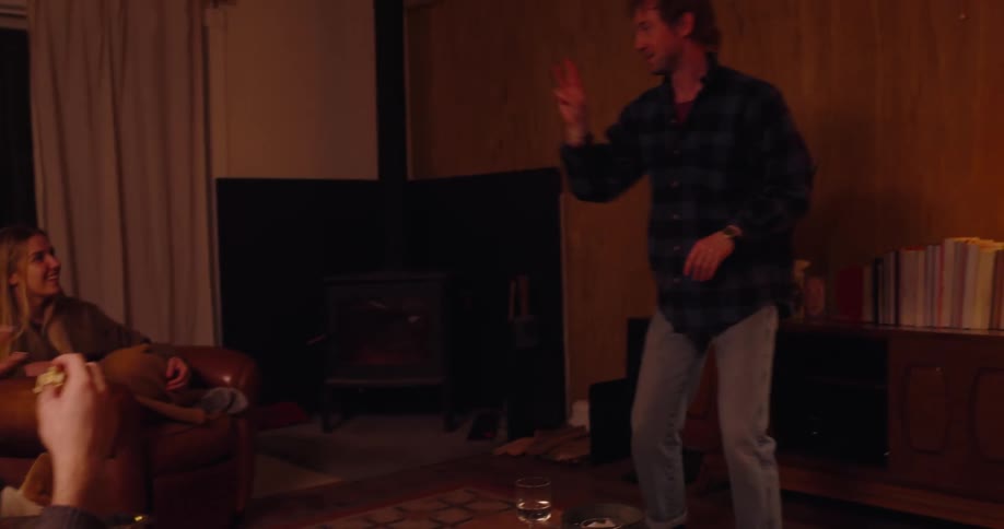 A group of friends are playing charades and eating popcorn in a living room